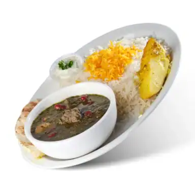 Beef and herb stew in a bowl beside rice, a potato wedge and pita
